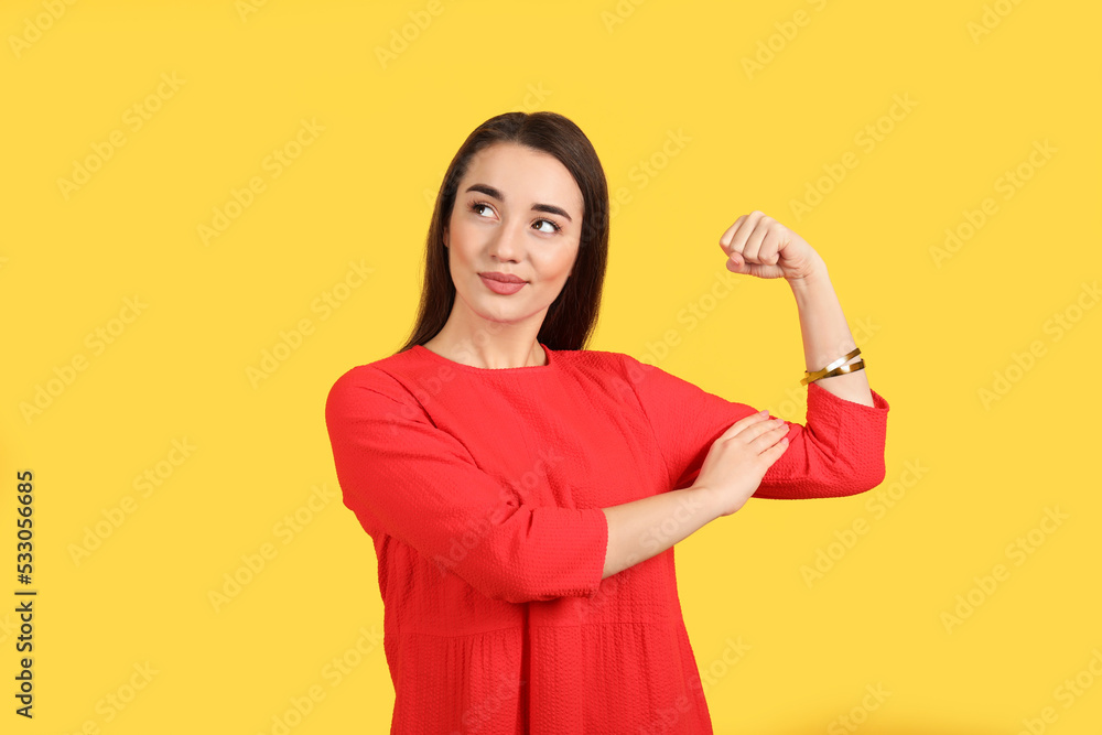 Emotional strong woman as symbol of girl power on yellow background. 8 March concept Emotional strong woman as symbol of girl power on yellow background. 8 March concept