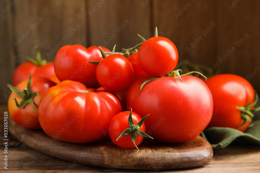 Many different ripe tomatoes on wooden table, closeup Many different ripe tomatoes on wooden table, closeup
