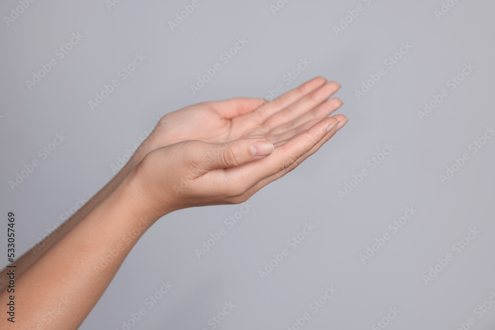 Woman stretching hands against light grey background, closeup. Space for text Woman stretching hands against light grey background, closeup. Space for text