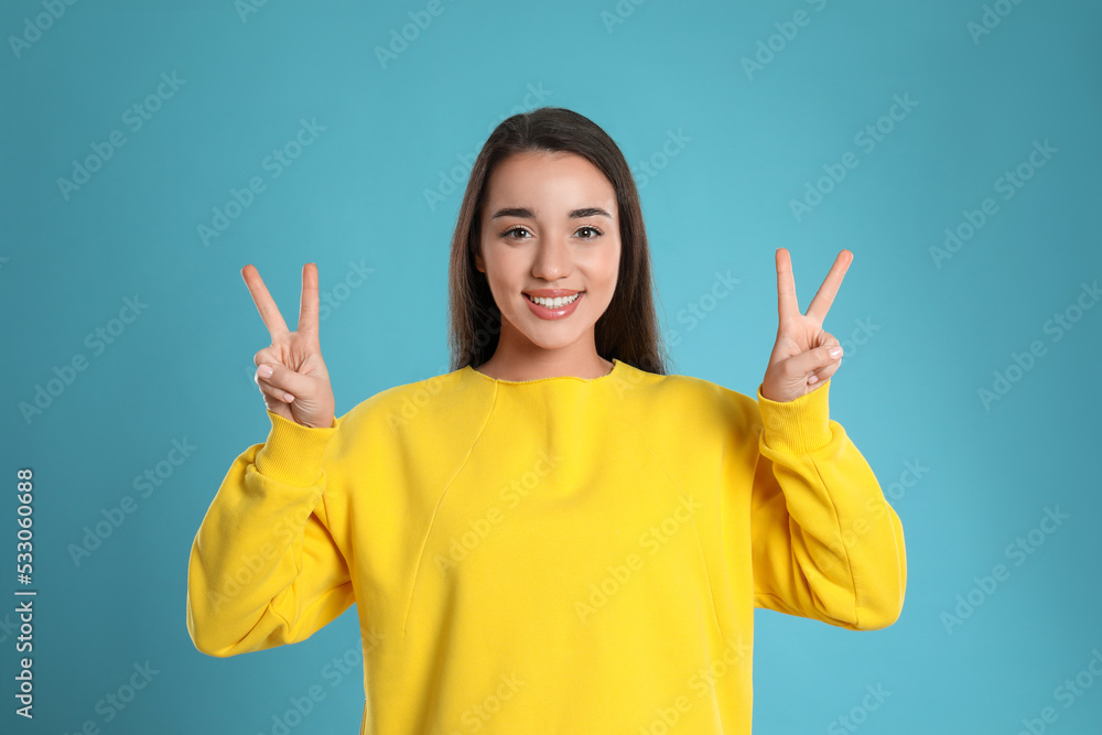 Woman showing number four with her hands on light blue background Woman showing number four with her hands on light blue background