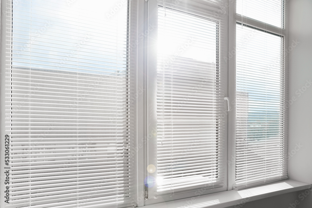 Stylish window with horizontal blinds in room Stylish window with horizontal blinds in room