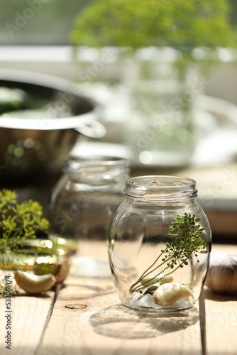 Empty glass jar and ingredients prepared for canning on wooden table indoors