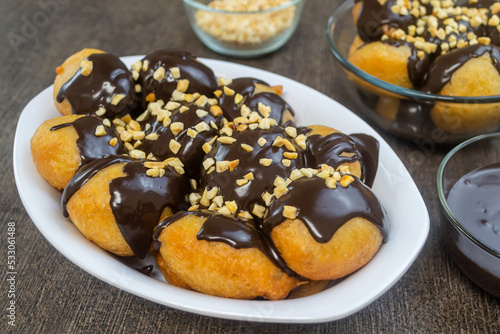 Loukoumades (Greek Donuts) or donat yunani combined with melted chocolate topping, have a crunchy texture on the outside and soft on the inside. photo