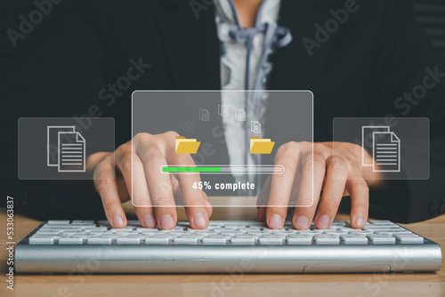 Transfer files data system relocation concept, Person hand typing keyboard computer waiting for transfer file process with loading bar icon on virtual screen. photo