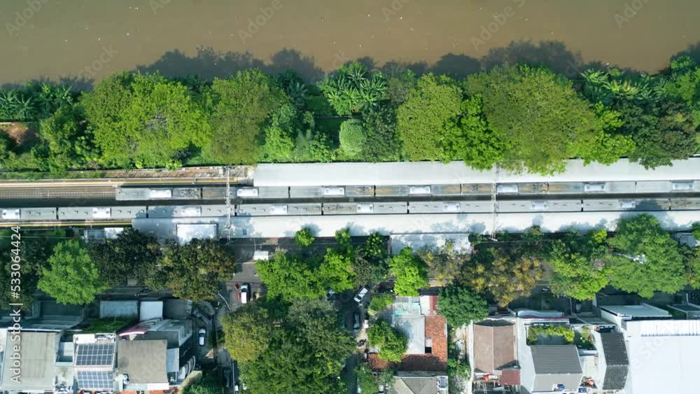 Top down view of train moving near Ciliwung river Top down view of train moving near Ciliwung river