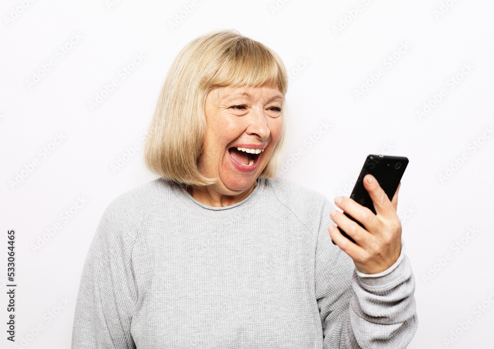 Portrait of attractive blond senior woman talking by mobile phone over white background Portrait of attractive blond senior woman talking by mobile phone over white background