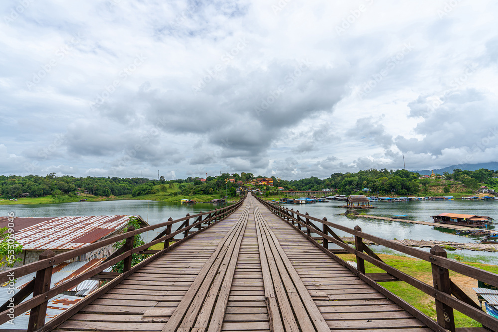 Fototapeta premium Mon Bridge, wooden bridge over the river In Sangkhlaburi District, Kanchanaburi, natural attractions Landmark of Thailand