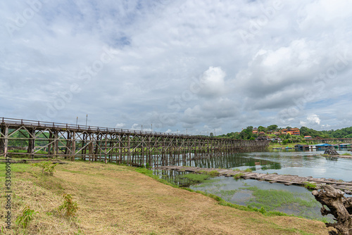 Fototapeta Naklejka Na Ścianę i Meble -   Mon Bridge, wooden bridge over the river In Sangkhlaburi District, Kanchanaburi, natural attractions Landmark of Thailand