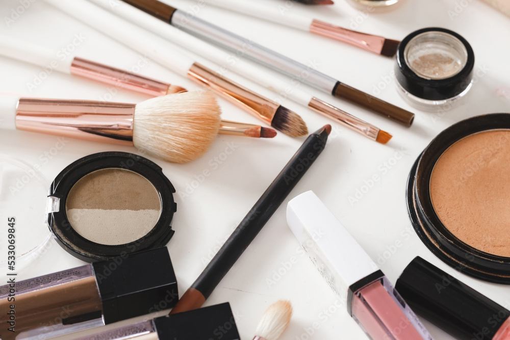 make-up tools and cosmetics on white table. Decorative cosmetics, brushes, eyes shadow, pencils with foundation on dressing table or beauty salon make-up tools and cosmetics on white table. Decorative cosmetics, brushes, eyes shadow, pencils with foundation on dressing table or beauty salon
