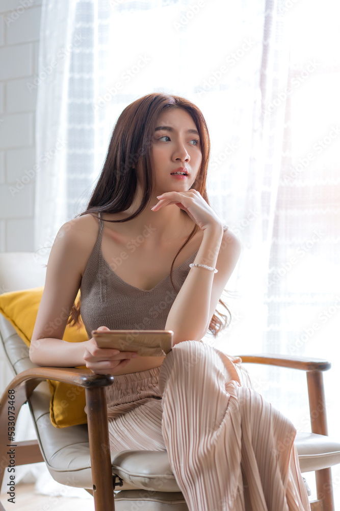 Beautiful woman relaxing and using smart tablet at living room, Education technology and internet concept Beautiful woman relaxing and using smart tablet at living room, Education technology and internet concept