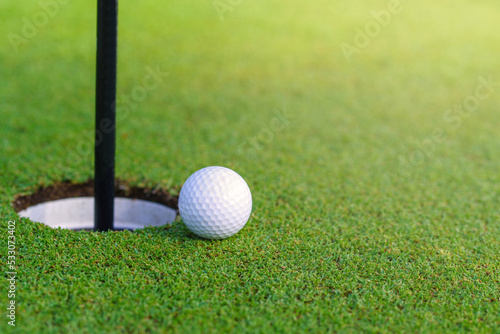 Golf ball on lip of cup at golf court