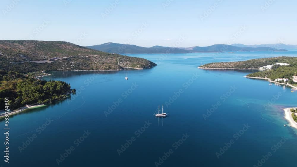 Aerial view of a small sailing boat navigating the blue water on Mediterranean Sea in Slano, Dubrovnik, Croatia. Aerial view of a small sailing boat navigating the blue water on Mediterranean Sea in Slano, Dubrovnik, Croatia.
