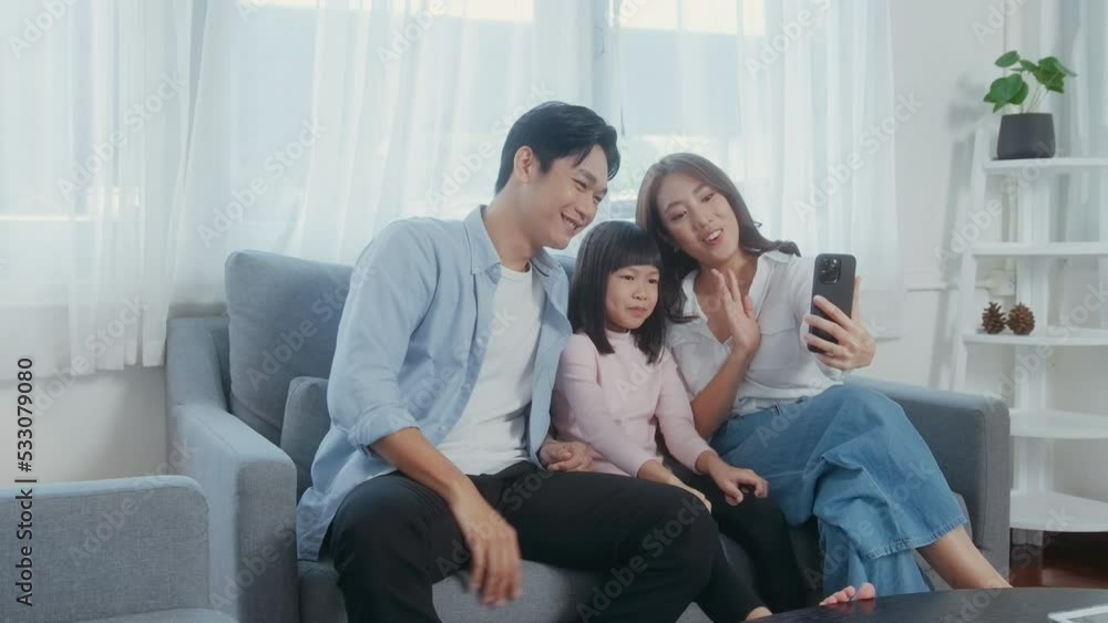 Asian family with children holding smartphone and making video call at home Asian family with children holding smartphone and making video call at home