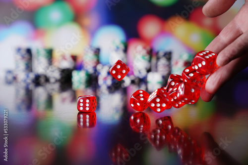 Casino theme. Gambling games. Dices, cards and poker chips on a colorful bokeh background.