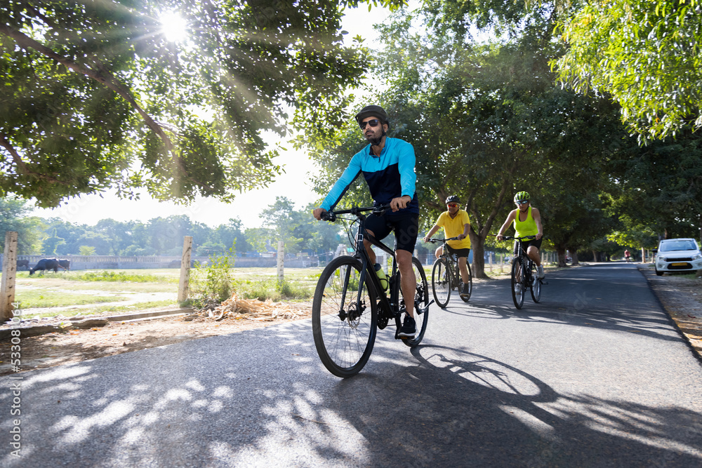 Fototapeta premium Confident cyclists riding bicycle on countryside road 