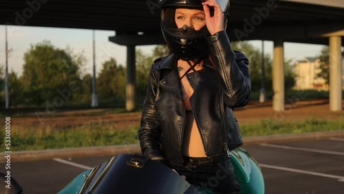 Anonymous cool woman sitting on motorbike on city street