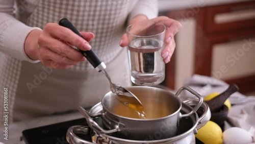 Wallpaper Mural Cooking hollandaise sauce - Woman pours water into metal steamer pot Torontodigital.ca