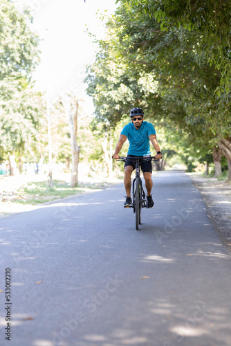 Young man in sportswear riding bicycle outdoors 