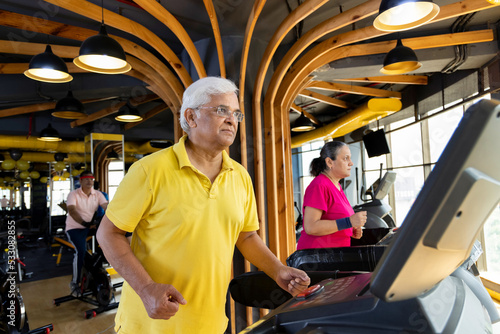 Men and woman in sportswear doing cardio workout at gym 