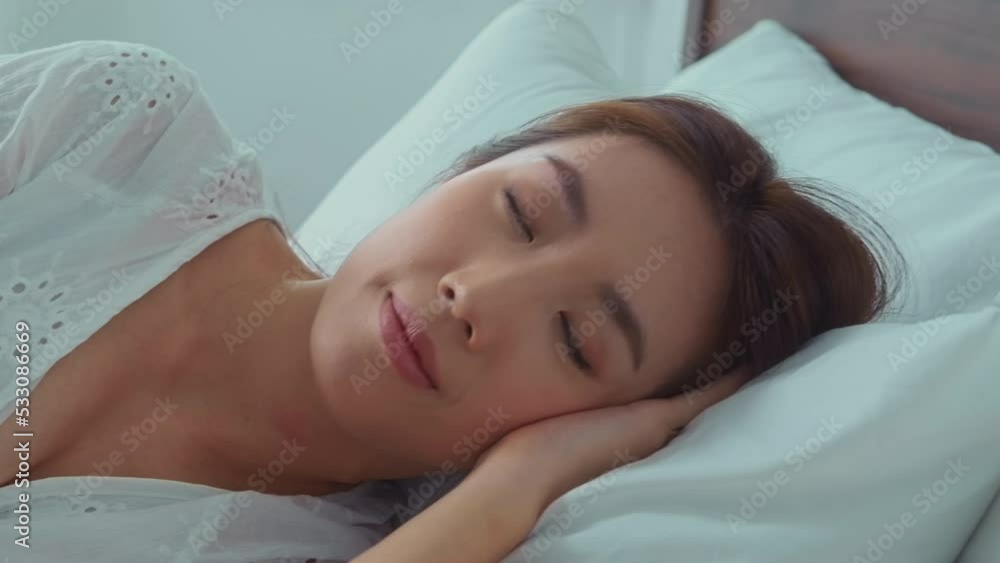  young asian woman sleeping on the bed in bedroom, happy healthy lifestyle concept