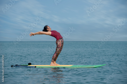 kite surfing in the sea. Woman doing YOGA on a SUP board in the sea. person on the beach. 