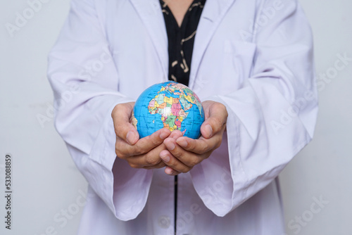 Close-up of scientist in a white lab coat with a globe isolated over white background.
