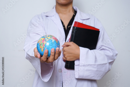 Close-up of scientist hands in a white lab coat holding a books and globe earth isolated over white background.