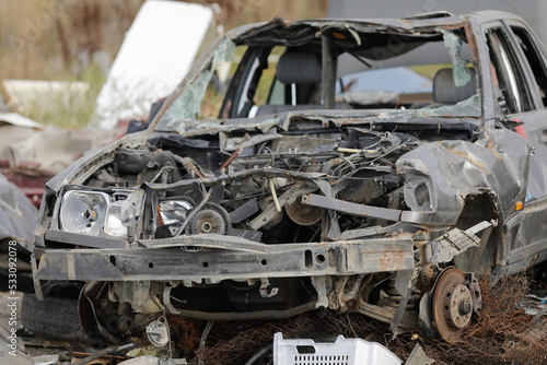 Details with destroyed cars or car parts in a makeshift scrap yard.