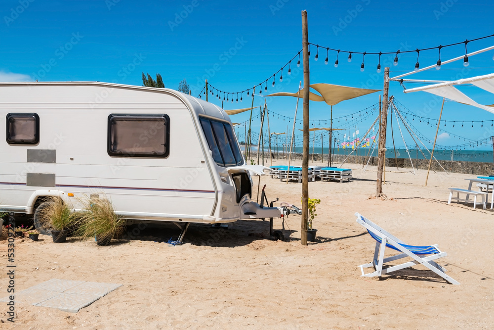 Camper RV car and bed chair on white beach in summer, Cha Am