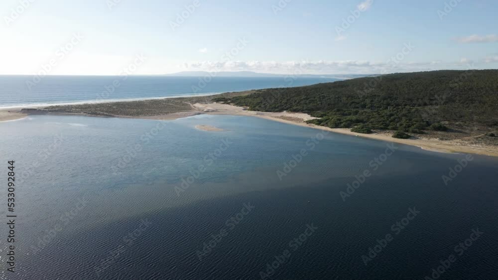 Aerial view of Lagoa de Albufeira, a natural lake meeting the Atlantic Ocean in south Portuguese coastline, Sesimbra Municipality, Setubal, Portugal. Aerial view of Lagoa de Albufeira, a natural lake meeting the Atlantic Ocean in south Portuguese coastline, Sesimbra Municipality, Setubal, Portugal.