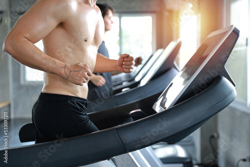 close up image of healthy and handsome caucasian muscle man in shirtless who running on excerise machine in gym