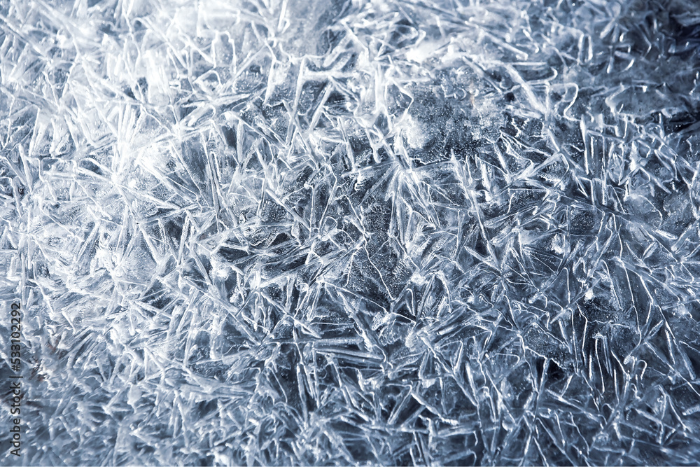 The texture of the ice surface. Winter background, festive background in the form of ice crystals, in natural deep blue color. The texture of the ice surface. Winter background, festive background in the form of ice crystals, in natural deep blue color.