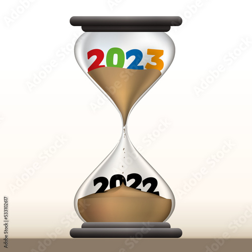 Concept du temps qui passe et du passage à la nouvelle année, avec un sablier qui présente 2023 en faisant disparaître 2021