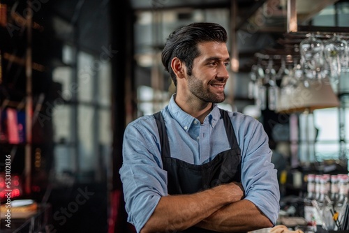 Photo of a handsome bartender behind the bar in a sky lounge bar in Bangkok