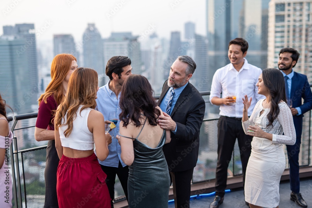 Obraz premium Photo of a group of businessmen and businesswomen mingle with each other drinking wine and champagne on a rooftop bar celebrating the successful of company latest deal and hit target goal of the year