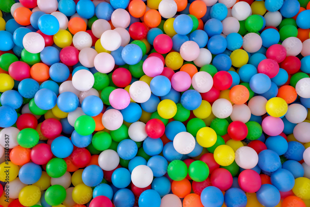 Multi colored, highly saturated plastic balls, in soft play ball pit, at a child's play park. Colorful balloon. Multi colored, highly saturated plastic balls, in soft play ball pit, at a child's play park. Colorful balloon.