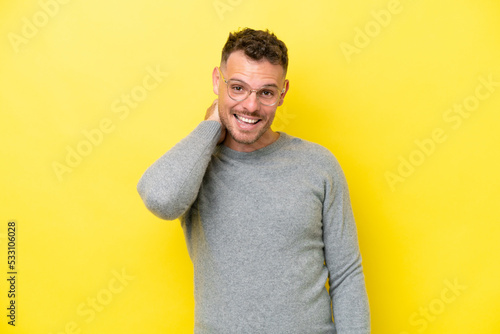 Young caucasian handsome man isolated on yellow background laughing