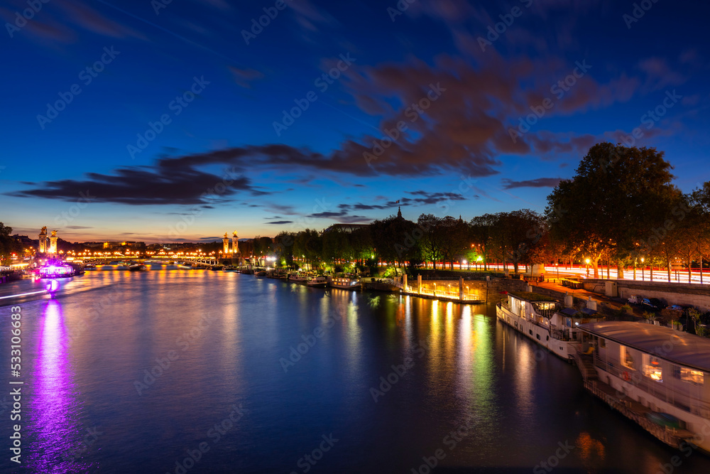 The Pont Alexandre III bridge in Paris by the Seine river at night. France