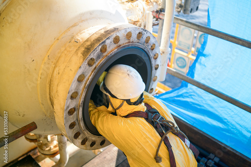 Worker cleaning internal pressure vessel in confine space. photo