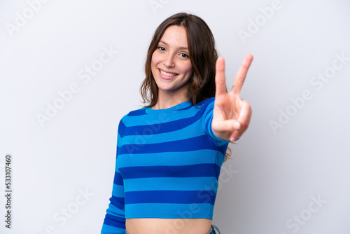 Young caucasian woman isolated on white background smiling and showing victory sign