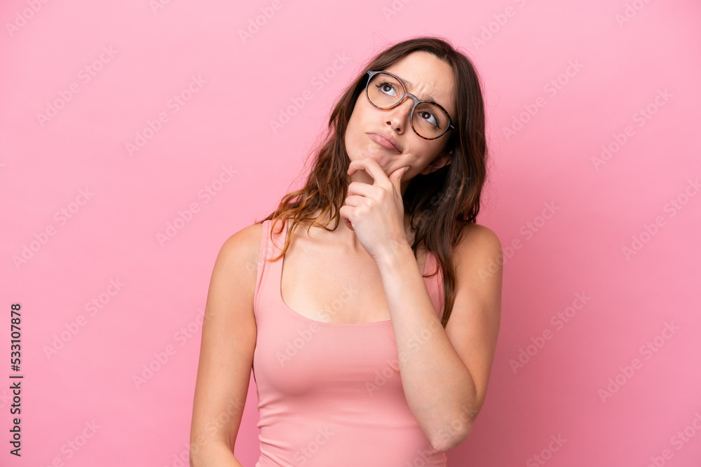 Young caucasian woman isolated on pink background having doubts Young caucasian woman isolated on pink background having doubts