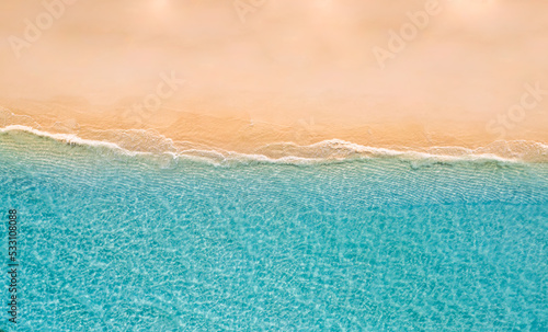 Summer seascape beautiful waves, blue sea water in sunny day. Top drone view. Sea aerial view, amazing tropical nature background. Beautiful bright sea waves surf on bright Mediterranean beach sand