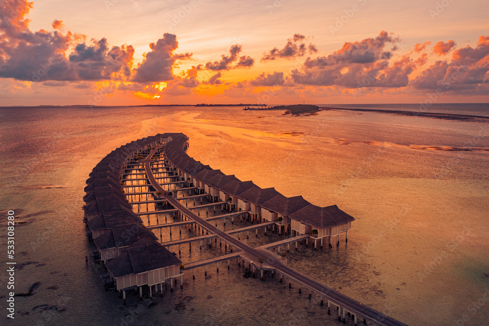 Fototapeta premium Amazing beach landscape. Beautiful Maldives sunset seascape view. Horizon colorful sea sky clouds, over water villa pier pathway. Tranquil island lagoon, tourism travel background. Exotic vacation 