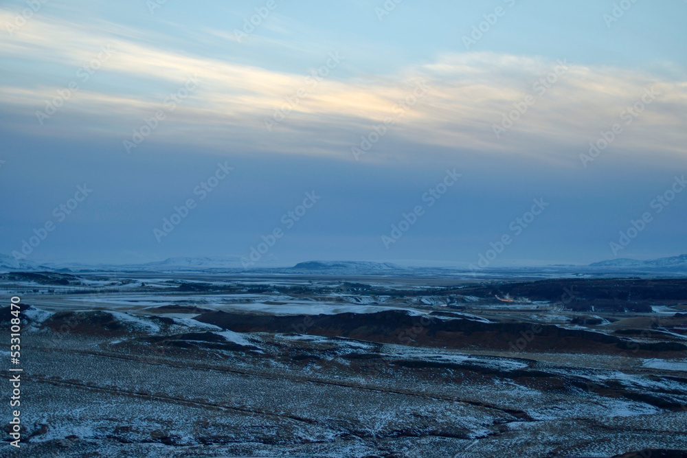 Iceland blue hour with yellow clouds over winter mountain landscape with snow