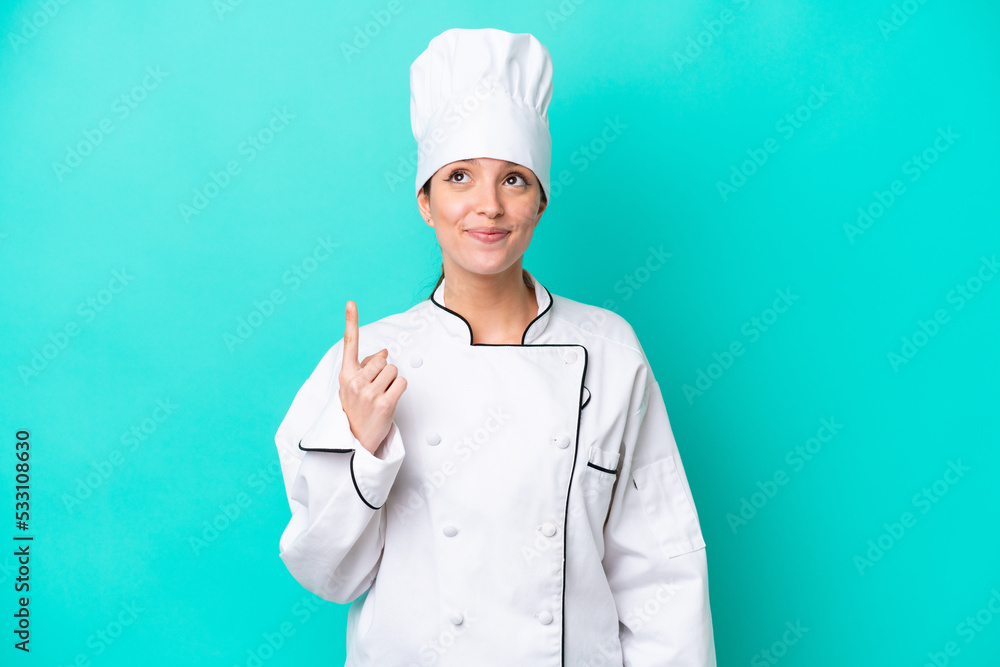 Young caucasian chef woman isolated on blue background pointing with the index finger a great idea Young caucasian chef woman isolated on blue background pointing with the index finger a great idea