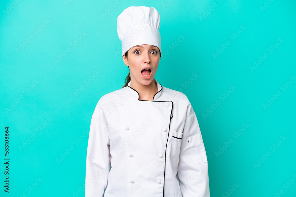 Young caucasian chef woman isolated on blue background with surprise facial expression Young caucasian chef woman isolated on blue background with surprise facial expression