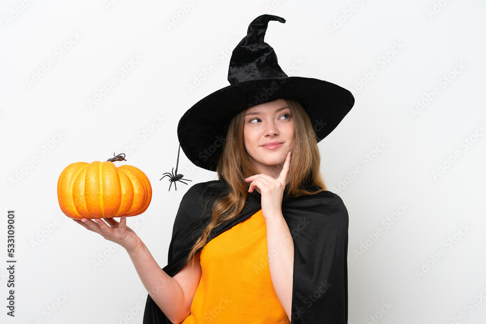 Young pretty woman costume as witch holding a pumpkin isolated on white background thinking an idea while looking up Young pretty woman costume as witch holding a pumpkin isolated on white background thinking an idea while looking up