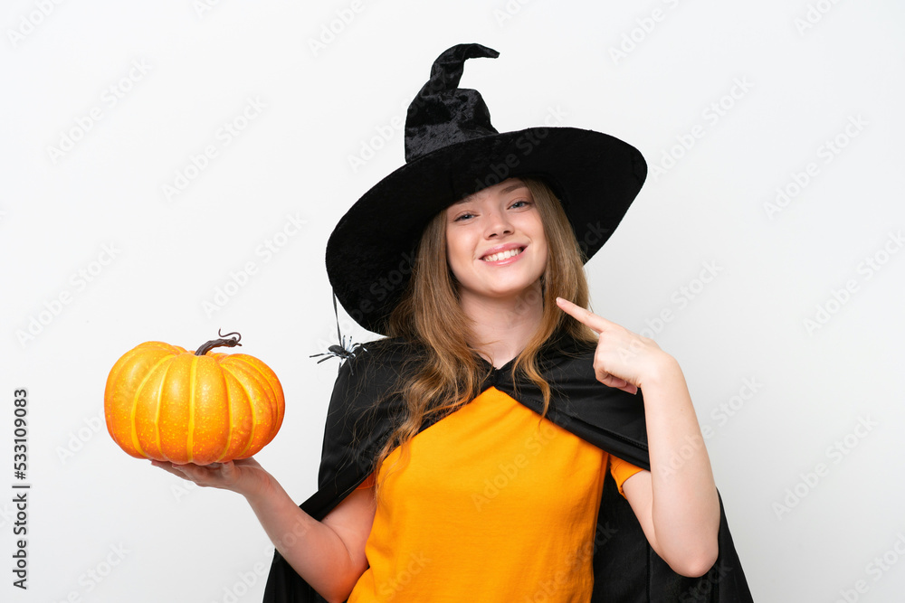 Young pretty woman costume as witch holding a pumpkin isolated on white background giving a thumbs up gesture Young pretty woman costume as witch holding a pumpkin isolated on white background giving a thumbs up gesture