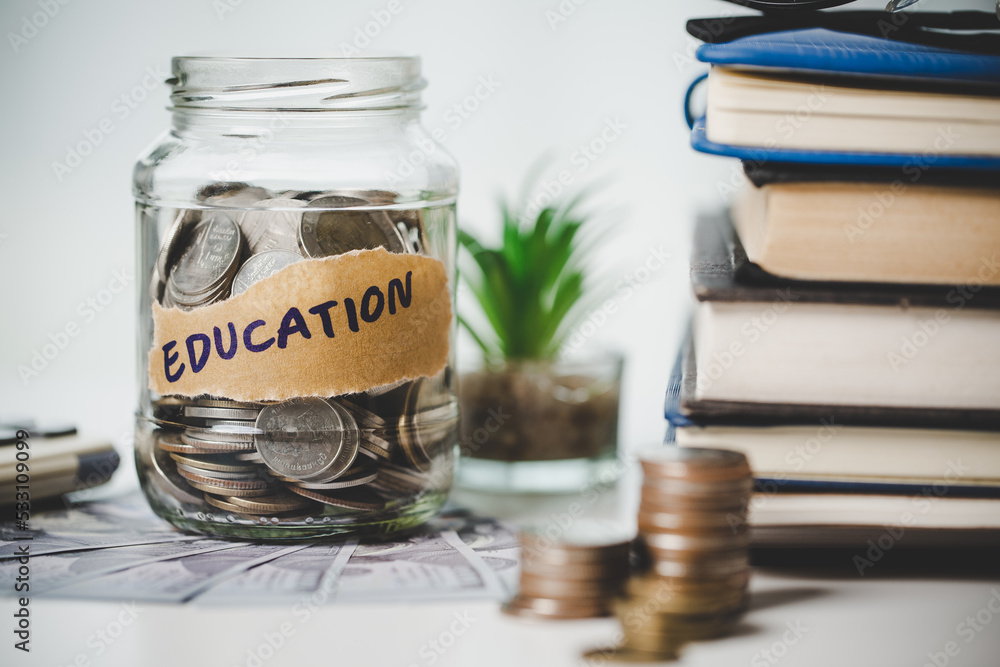 close-up education object with stack money coin-cash dollar and glass jar on background. Concept to saving money income for study, Calculating student finance costs and investment budget loan close-up education object with stack money coin-cash dollar and glass jar on background. Concept to saving money income for study, Calculating student finance costs and investment budget loan