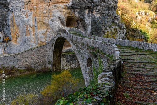 Kokori's old arch stone bridge (Noutsos) during fall season situated on the river of Voidomatis in Zagori, Epirus Greece. photo